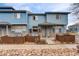 Blue townhomes with welcoming entrances and beautiful landscaping features at 12063 Monaco Ct, Brighton, CO 80602