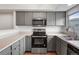 Efficient kitchen with gray cabinets, modern appliances, and ample counter space at 12063 Monaco Ct, Brighton, CO 80602