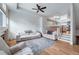 Bright living room featuring white sofas, a modern ceiling fan, and an open floor plan at 12063 Monaco Ct, Brighton, CO 80602