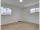 Clean bedroom with wood floors, two windows, and neutral paint, offering a blank canvas at 3290 S Holly St, Denver, CO 80222