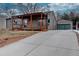 Exterior view of home showing driveway and garage, complimented by mature trees and nice green space at 3290 S Holly St, Denver, CO 80222