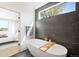 Tranquil bathroom featuring a freestanding tub, a tiled wall, and a view to the outside at 4236 Zuni St, Denver, CO 80211