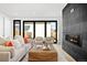 Bright living room boasts stylish fireplace, modern furniture, and doors to the outdoors at 4236 Zuni St, Denver, CO 80211