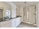 Modern bathroom with double vanity, sleek countertops, tiled floors, and glass-enclosed shower at 39867 Floyd St, Elizabeth, CO 80107