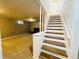 View of the stairs leading to the finished basement with carpet and painted walls at 2964 S Yates St, Denver, CO 80236