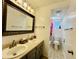 Bright bathroom featuring a double sink vanity, large mirror, and tiled floors at 2964 S Yates St, Denver, CO 80236