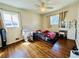 Cozy bedroom with hardwood floors, two windows, ceiling fan, and neutral-toned walls at 2964 S Yates St, Denver, CO 80236