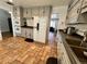 View of the kitchen, featuring a refrigerator, tile floors, painted cabinets, and modern appliances at 2964 S Yates St, Denver, CO 80236