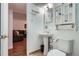 Small bathroom with a toilet, sink, vanity and view into a living room space at 1781 Uinta St, Denver, CO 80220