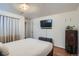 Cozy bedroom with laminate floors, a TV, and white walls with neutral decor at 1781 Uinta St, Denver, CO 80220