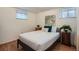 Comfortable bedroom with a bed, two windows, laminate floors, and neutral decor at 1781 Uinta St, Denver, CO 80220