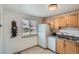 Efficient kitchen space with wooden cabinets, white appliances, and a wine rack at 1781 Uinta St, Denver, CO 80220