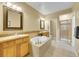 Luxurious bathroom featuring a soaking tub, separate shower, double vanities, and neutral tile at 9246 Sori Ln, Highlands Ranch, CO 80126