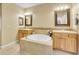 Bathroom featuring double vanities, a large tub, and a tiled backsplash, blending style and functionality at 9246 Sori Ln, Highlands Ranch, CO 80126