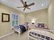 Bright bedroom with two twin beds, a ceiling fan, neutral walls, and a large window with shutters at 9246 Sori Ln, Highlands Ranch, CO 80126