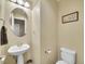 Cozy powder room with pedestal sink, oval mirror, and toilet at 9246 Sori Ln, Highlands Ranch, CO 80126