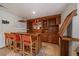 Basement with custom-built wood bar, tile flooring, overhead lights, and comfortable seating at 960 Aspen Pl, Evergreen, CO 80439