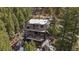Aerial shot of a gray house with multiple decks surrounded by forest at 960 Aspen Pl, Evergreen, CO 80439