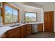 Close up view of the kitchen with solid countertops, wood cabinets, and mountain views from large windows at 960 Aspen Pl, Evergreen, CO 80439