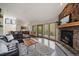 Inviting living room features a stone fireplace, wood floors, and large windows with views of the outdoors at 960 Aspen Pl, Evergreen, CO 80439