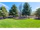 Spacious backyard offers privacy with mature trees and a charming bird bath feature at 2912 Lake Park Way, Longmont, CO 80503