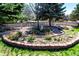 Backyard flowerbed is bordered with brick and features mature plants at 2912 Lake Park Way, Longmont, CO 80503