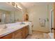 Bathroom featuring double sinks, white countertops, and a shower and tub at 2912 Lake Park Way, Longmont, CO 80503