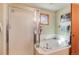 Bathroom featuring a tiled tub with glass shower door, and a small window at 2912 Lake Park Way, Longmont, CO 80503