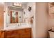 A cozy bathroom with a white sink, tiled countertop, and wooden cabinets at 2912 Lake Park Way, Longmont, CO 80503