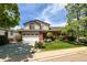 Charming two-story home with a well-maintained lawn, red accents, mature trees, and an attached two-car garage at 2912 Lake Park Way, Longmont, CO 80503