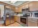 Bright kitchen featuring stainless steel appliances, wooden cabinetry, and hardwood floors at 2912 Lake Park Way, Longmont, CO 80503