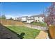 Spacious backyard featuring healthy green grass, mature trees, and secure fencing, perfect for outdoor enjoyment at 5506 S Quemoy Cir, Aurora, CO 80015