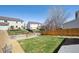 Well-maintained backyard with lush green grass, mature trees, and a fenced border, ideal for outdoor activities at 5506 S Quemoy Cir, Aurora, CO 80015