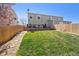 Expansive backyard features a deck with outdoor seating, green grass and mature trees, ideal for outdoor living at 5506 S Quemoy Cir, Aurora, CO 80015