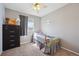 Cozy bedroom with natural light, plush carpet, and a ceiling fan at 5506 S Quemoy Cir, Aurora, CO 80015