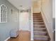 Welcoming entryway with hardwood floors, staircase, decorative windows, and a stylish ottoman at 5506 S Quemoy Cir, Aurora, CO 80015