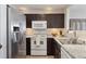 Modern kitchen with stainless steel appliances, granite countertops, and dark wood cabinets at 5506 S Quemoy Cir, Aurora, CO 80015