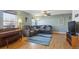 Inviting living room with hardwood floors, a cozy gray couch, a piano, and lots of natural light at 5506 S Quemoy Cir, Aurora, CO 80015