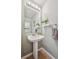 Half-bathroom featuring a pedestal sink, accent plants, and modern fixtures at 5506 S Quemoy Cir, Aurora, CO 80015