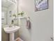 Half-bathroom featuring a pedestal sink, accent plants, and modern fixtures at 5506 S Quemoy Cir, Aurora, CO 80015