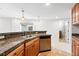 Basement bar area with stainless steel dishwasher, stone countertops and cabinetry at 2832 Danbury Ave, Highlands Ranch, CO 80126