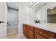 Bright bathroom featuring tile flooring, a tub with shower, and a vanity with wood cabinets at 2832 Danbury Ave, Highlands Ranch, CO 80126