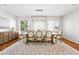 Bright dining room with a large farmhouse table, elegant chairs, and a patterned rug at 2832 Danbury Ave, Highlands Ranch, CO 80126
