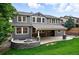 Rear view of the home displaying the covered patio, outdoor fireplace, and a spacious, well-maintained lawn at 2832 Danbury Ave, Highlands Ranch, CO 80126