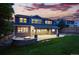 Exterior evening shot shows a covered patio, fire pit, and well-lit backyard with a manicured lawn at 2832 Danbury Ave, Highlands Ranch, CO 80126