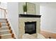 Living room fireplace with stone surround and dark mantel, complemented by a staircase with wood and metal railings at 2832 Danbury Ave, Highlands Ranch, CO 80126