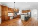 Spacious kitchen featuring a central island, stainless steel appliances, custom cabinets, and hardwood floors at 2832 Danbury Ave, Highlands Ranch, CO 80126