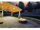 Illuminated stone fire pit on the back patio complemented by a wood ceiling and well-manicured lawn at 2832 Danbury Ave, Highlands Ranch, CO 80126