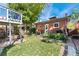 Charming backyard with a two story deck, lush grass, mature trees, and a well-maintained garden at 511 S Pennsylvania St, Denver, CO 80209