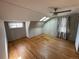Bedroom with hardwood floors, a ceiling fan, skylights, and gray-washed paneled walls at 511 S Pennsylvania St, Denver, CO 80209